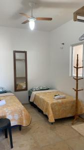 a bedroom with two beds and a ceiling fan at Casa na praia _Ceará in Acaraú