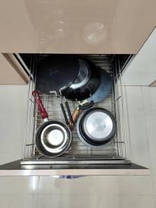 a group of utensils in a metal rack at 2BHK AC Service Apartment 403 in Pune +65 photos