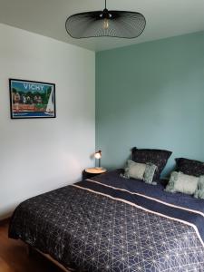 1 dormitorio con 1 cama y ventilador de techo en Cosy Saint Yorre en Saint-Yorre