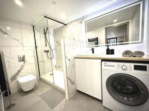 a bathroom with a washing machine and a shower at Cocon proche Disneyland et Paris in Torcy