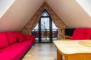 sala de estar con sofá rojo y mesa en Nasza Chata - Pokoje i Apartamenty, en Zakopane