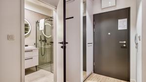 łazienka z prysznicem i szklanymi drzwiami w obiekcie Rezydencja Niechorze 224 - 5D Apartamenty w mieście Niechorze