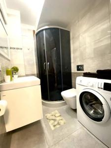 ein Badezimmer mit einer Waschmaschine und einem WC in der Unterkunft Szczyrk Apartament Dziupla - Słoneczna Góra in Szczyrk