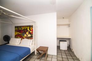 Un dormitorio con una cama azul y una pintura en la pared en Bellevie Experience en Cascavel