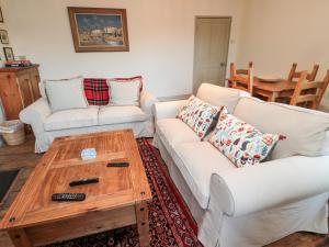 a living room with a white couch and a coffee table at Upper Oakwood in Alnwick