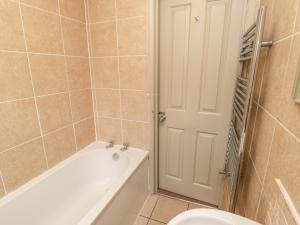 a bathroom with a bath tub and a toilet at Upper Oakwood in Alnwick +24 photos
