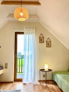 a bedroom with a window and a bed and a table at Fajne Domki in Władysławowo