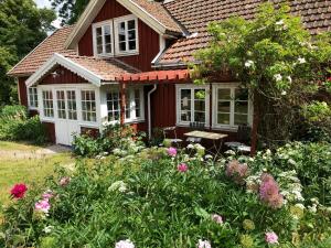 a red house with a garden with flowers at Övra Berg in Ullared
