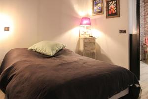 una camera da letto con un letto con una lampada su un comodino di Large cozy nest on the outskirts of Paris ad Asnières