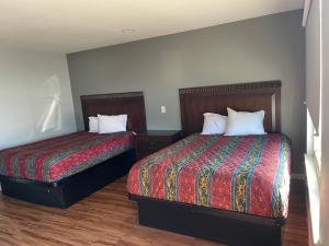 two beds in a small room with two beds sidx sidx sidx at CoachLight Motel in Hemet
