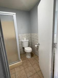 a bathroom with a toilet and a shower at CoachLight Motel in Hemet