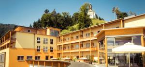 a hotel with a mountain in the background at Heilmoorbad Schwanberg in Schwanberg