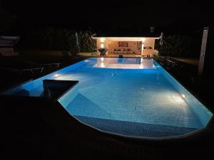 a large swimming pool lit up at night at Olympos Sunset Residence - Mountain and Sea View in Litochoro