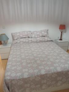 a bed in a bedroom with two nightstands and two lamps at Piso junto al mar de 80m² in Villajoyosa