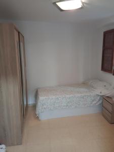 um pequeno quarto com uma cama e uma cómoda em Piso junto al mar de 80m² em Villajoyosa