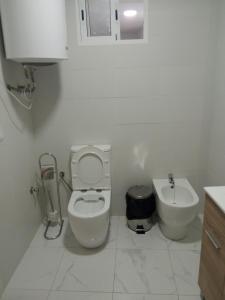 a white bathroom with a toilet and a sink at Piso junto al mar de 80m² in Villajoyosa +19 photos