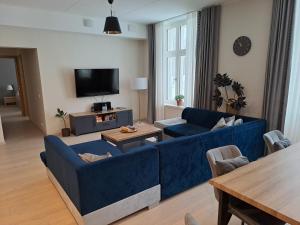 a living room with a blue couch and a table at Aleksi Apartments in Tartu