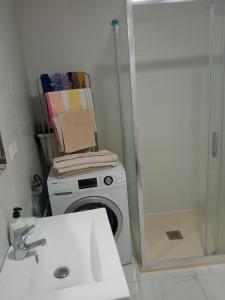 uma casa de banho com uma máquina de lavar roupa e um lavatório em Piso junto al mar de 80m² em Villajoyosa