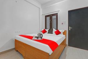 坎普爾的住宿－Flagship Sai Galaxy Hotel & Restaurant，一间卧室配有一张带红色枕头的大床