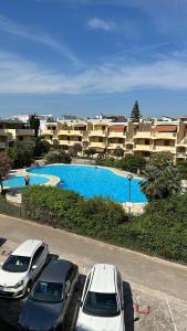 two cars parked in a parking lot in front of a pool at DomoDé in Alghero