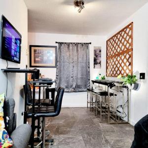 a living room with tables and chairs and a television at Escape Pine Forest- Getaway Experience in Summerville