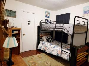 a bedroom with two bunk beds and a lamp at Escape Pine Forest- Getaway Experience in Summerville