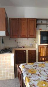 a kitchen with wooden cabinets and a table with a table sidx sidx sidx at Appartamenti S'Agapo' in Catanzaro Lido