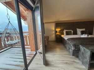 sypialnia z łóżkiem i wiszącą huśtawką w obiekcie Les Trois Chaufatons - Chalets Boutiques w mieście Montriond