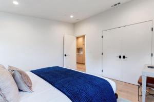 ein Schlafzimmer mit weißen Wänden und ein Bett mit einer blauen Decke in der Unterkunft Dazzling Modern Home Close to Downtown Palo Alto and Stanford in Menlo Park