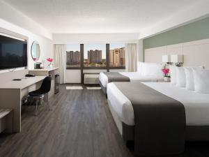 奧蘭多的住宿－阿凡提棕櫚度假酒店，酒店客房配有两张床和一张书桌