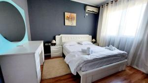 a bedroom with a white bed and a mirror at Signature Idea hotel in Tirana