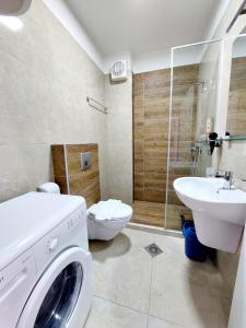 uma casa de banho com uma máquina de lavar roupa e um lavatório em Signature Idea hotel em Tirana