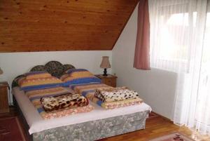 uma cama com quatro almofadas num quarto em Ilda Apartments em Harkány
