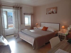 ThueytsにあるHôtel La Gravenneのベッドルーム1室(ベッド1台、椅子2脚、窓付)