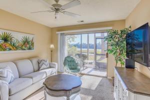 a living room with a couch and a table at Pawleys Island Condo with Screened Porch and Golfing! in Pawleys Island