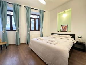 a bedroom with a large bed with blue curtains at Holiday Apartments Bucharest in Bucharest