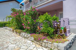 un jardín de flores frente a una casa en Apartments ALEXIS, en Crikvenica