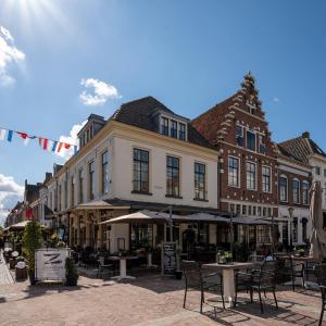 een straat met tafels en stoelen voor gebouwen bij Zilverzoen Slapen in Elburg
