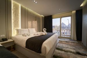 una camera da letto con un letto grande con una grande finestra di Pyramids Charm Hotel a Il Cairo