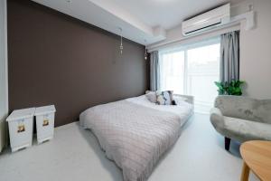 sypialnia z łóżkiem, krzesłem i oknem w obiekcie Seaside Tamachi - Vacation STAY 15581 w Tokio
