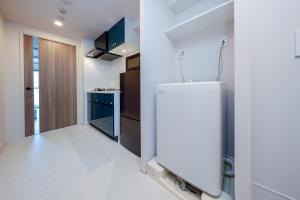 a white kitchen with a sink and a refrigerator at Seaside Tamachi - Vacation STAY 15740 in Tokyo