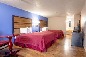 a hotel room with two beds and a table at Motel Puyallup in Puyallup +9 photos
