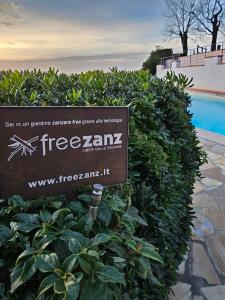 a sign in a bush next to a swimming pool at Borgo La Casaccia in Montaione