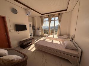 een slaapkamer met 2 bedden, een tv en een raam bij Alpha Hotel 