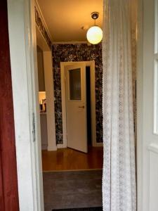 einen Flur mit einer Tür, die zu einem Zimmer führt in der Unterkunft The Guest House. in Gammelstaden