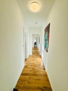 an empty hallway with white walls and wooden floors at Schicke Wohnung im grünen Hinterhof in Schwerin