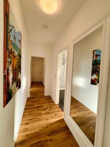 a hallway with wood floors and a mirror at Schicke Wohnung im grünen Hinterhof in Schwerin