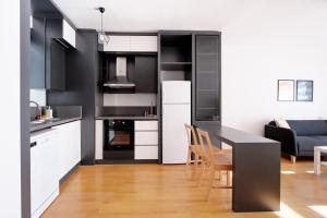 a kitchen with black cabinets and a table and chairs at Flat with Terrace Close to Transit in Ankara in Ankara