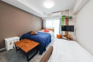 a bedroom with two beds and a table and a tv at Seaside Tamachi - Vacation STAY 15584 in Tokyo