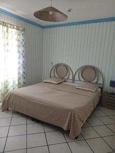 ein Schlafzimmer mit einem großen Bett in einem Zimmer in der Unterkunft Appart'hotel La croisière in Gourbeyre
